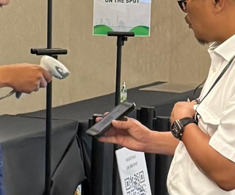 Staff scanning an attendee's QR e-ticket with a handheld scanner