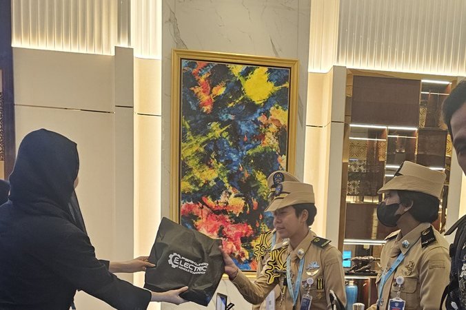 Delegates collecting conference kits at the Periklindo Electric Vehicle Conference registration desk